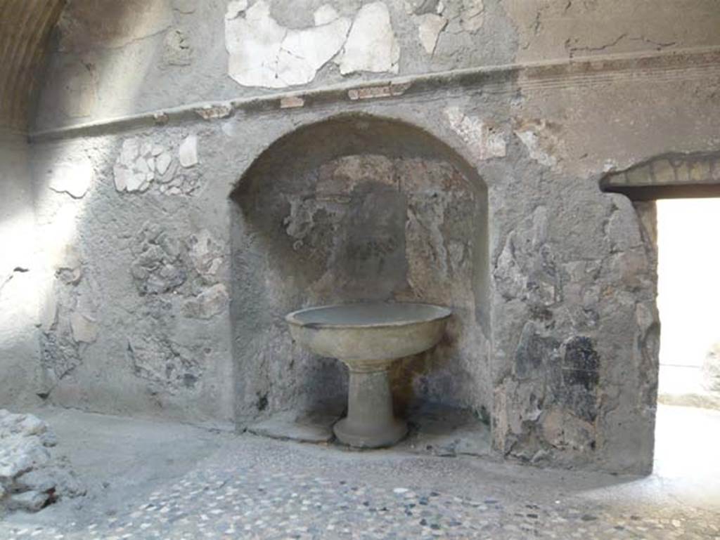 VI.1, Herculaneum. August 2013. North wall of apodyterium with cipollino marble basin (labrum) in an apse. Photo courtesy of Buzz Ferebee.
According to Maiuri, there was another basin in the corner, both of these were used for the washing of hands and feet before entering the frigidarium or tepidarium.
See Maiuri, A. (1977). Herculaneum, No. 53 of the series of guide-books to the museums, galleries and monuments of Italy, (p.37)